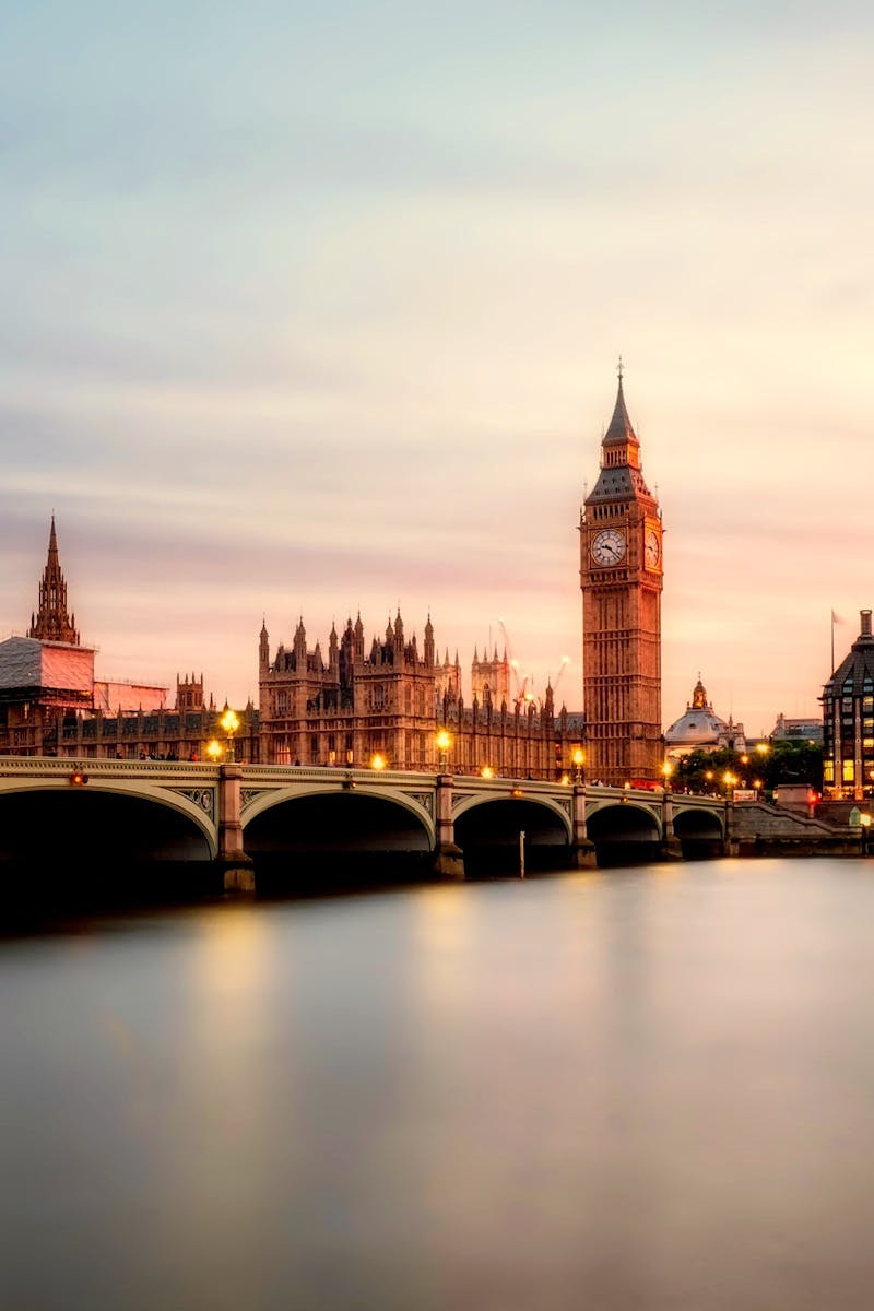 Scenic view of Big Ben and Westminster Bridge over the Thames River at sunset in London, UK.